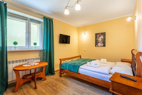 1 dormitorio con 1 cama y 1 mesa en Apart-Invest Apartament Paryski en Szklarska Poręba