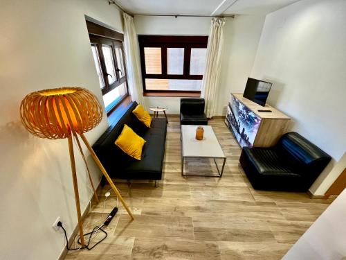 ein Wohnzimmer mit zwei Sofas und einem Fernseher in der Unterkunft Lotila Flats L'Infiestu in Infiesto