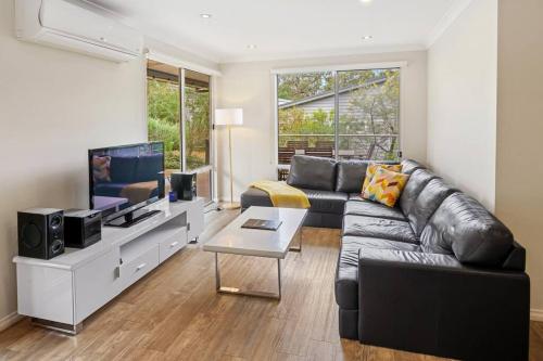 a living room with a couch and a tv at Viente @ Cape Villas Dunsborough in Dunsborough