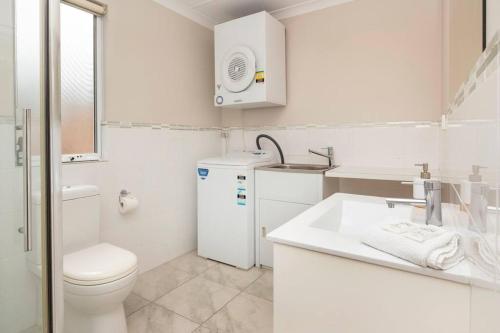 a white bathroom with a toilet and a sink at Viente @ Cape Villas Dunsborough in Dunsborough
