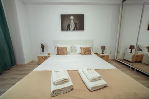 a bedroom with a bed with towels on it at Tatarasi Apartments - One Residence Iasi in Iaşi
