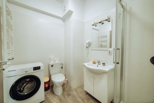 a bathroom with a washing machine and a sink at Tatarasi Apartments - One Residence Iasi in Iaşi
