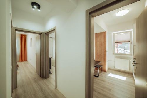 eine offene Tür, die in ein Zimmer mit einem Tisch führt in der Unterkunft Cozy Apartments - One Residence Iasi in Iaşi