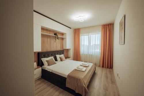 Schlafzimmer mit einem Bett und einem Fenster mit orangefarbenen Vorhängen in der Unterkunft Cozy Apartments - One Residence Iasi in Iaşi
