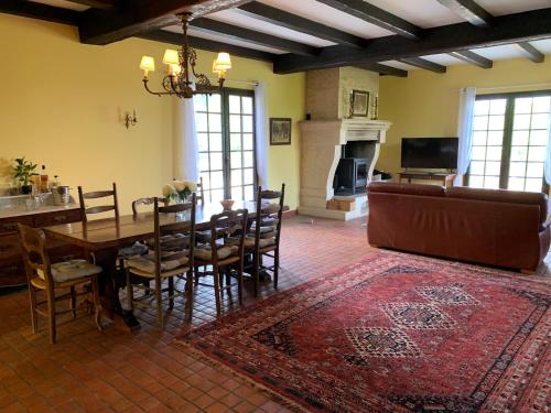 una sala da pranzo con tavolo, sedie e camino di View on Saint Emilion a Pujols-sur-Ciron