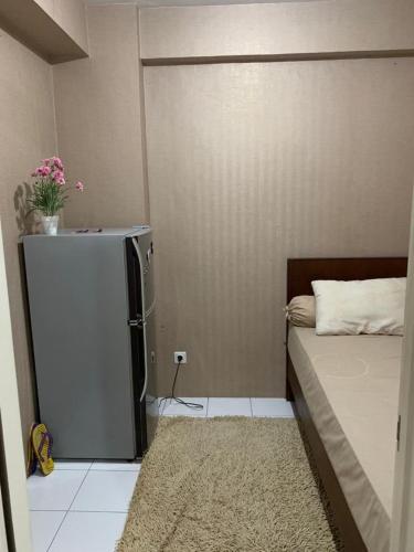 a small room with a refrigerator and a bed at RrProperty in Jakarta