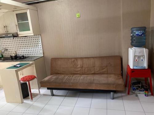 a living room with a couch and a machine in a kitchen at RrProperty in Jakarta