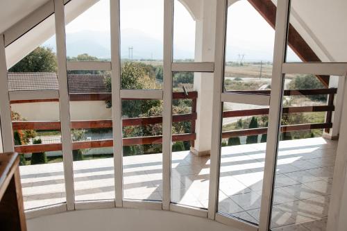 スンバタ・デ・ススにあるPensiunea Victoria Sambata de Susの大きな窓が備わる家のバルコニーから景色を望めます。