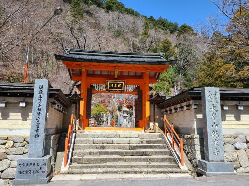 an orange gate with stairs in front of a building at Ichimaru Ryokan - Vacation STAY 77709v in Tenkawa