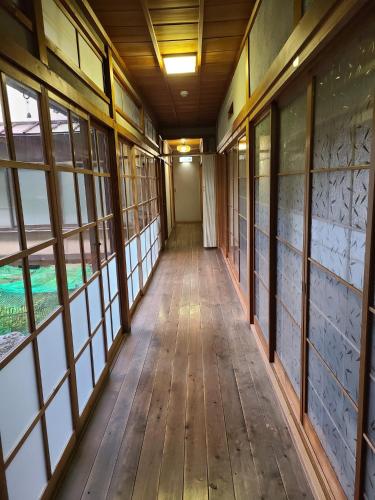 an empty corridor in a building with windows at Ichimaru Ryokan - Vacation STAY 77709v in Tenkawa