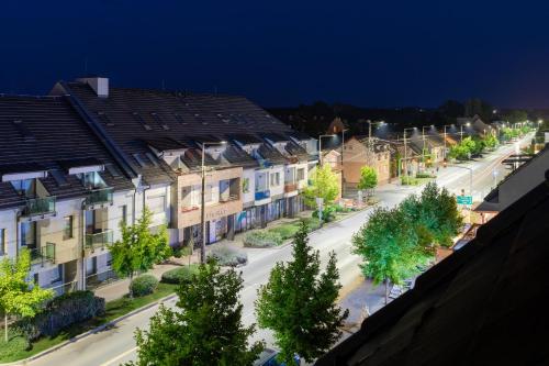 a city street with houses and trees at night at Zafír Apartman Sárvár in Sárvár