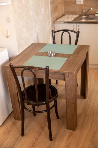 a wooden table with a chair and a kitchen at Garden apartment & parking in Kraljevo