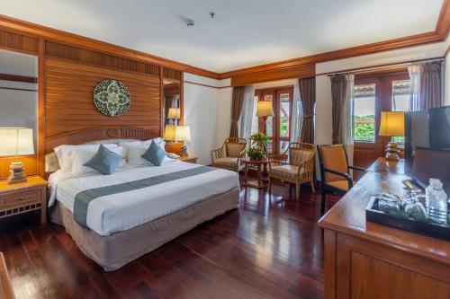 a hotel room with a bed and a television at Felix River Kwai Resort - SHA Plus,Certified in Kanchanaburi