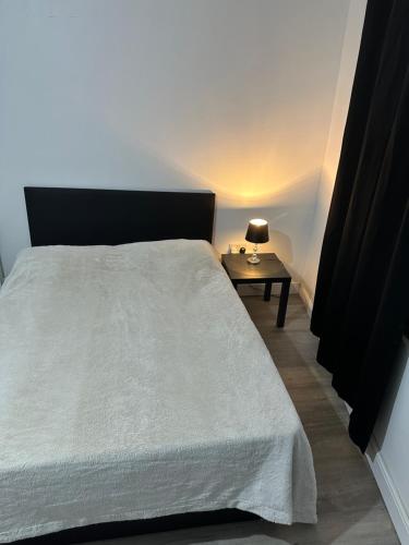 um quarto com uma cama e uma mesa com um candeeiro em Luxury apartment on Anfield em Liverpool