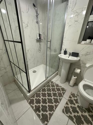 uma casa de banho com um chuveiro, um WC e um lavatório. em Luxury apartment on Anfield em Liverpool