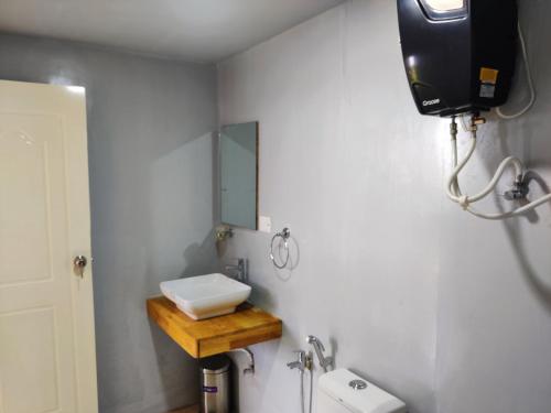a bathroom with a sink and a mirror at Group Cabin at Clapping Leaves in Hyderabad