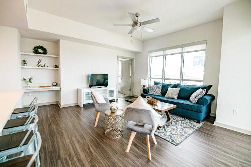 a living room with a blue couch and a tv at 2BR Uptown Furnished Apartment near Truist Fields apts in Charlotte