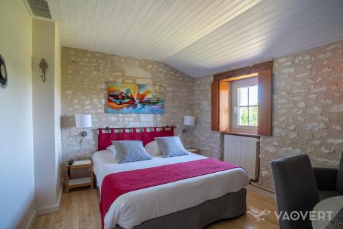 - une chambre avec un grand lit et une tête de lit rouge dans l'établissement Le Pigeonnier du Perron Hôtel, à Availles en Chatellerault