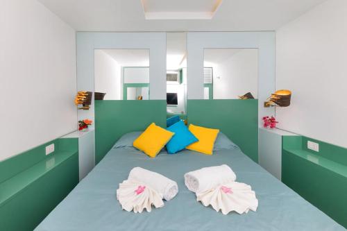 a bedroom with a blue bed with colorful pillows at Lemon House, Capri in Capri