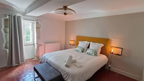 ein Schlafzimmer mit einem Bett mit zwei weißen Handtüchern darauf in der Unterkunft Le gîte de Varanges maison de ville au coeur de Givry classée 3 étoiles in Givry