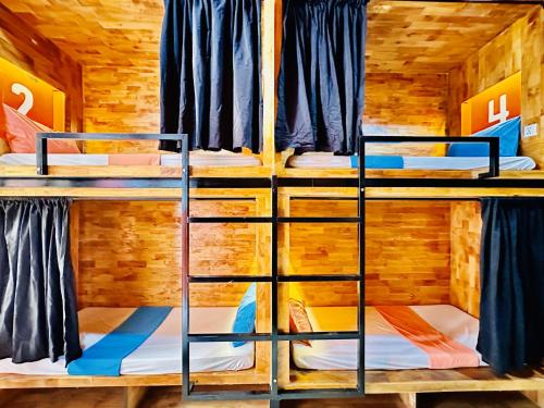 a room with three bunk beds in a cabin at THE PLACE Hostel & Rooftop Bar in Battambang