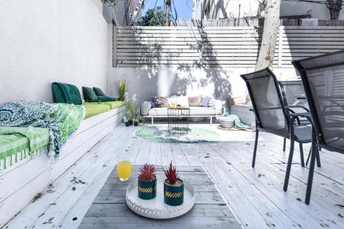 une terrasse avec un canapé, une table et des chaises dans l'établissement Modern & Chic Apartment w Patio Near Rothschild Blvd by Sea N' Rent, à Tel Aviv