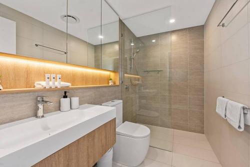 a bathroom with a toilet and a sink and a shower at Above Broadbeach casino 1BRplus Study ocean-city views in Gold Coast