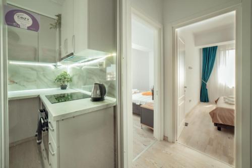 a white bathroom with a sink and a bedroom at Palace of Culture Dream Apartments and Studios Iasi in Iaşi