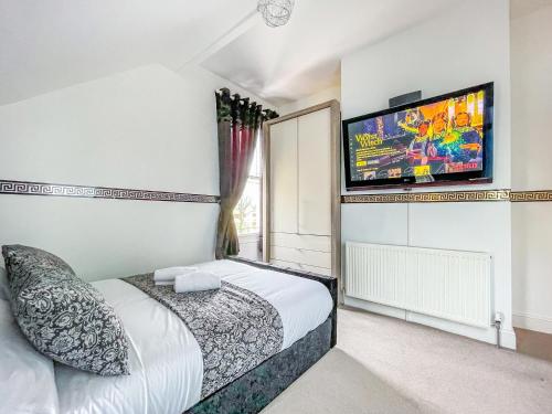 a bedroom with a bed and a flat screen tv at *RD9bC* For your most relaxed & Cosy stay + Free Parking + Free Fast WiFi * in Moortown