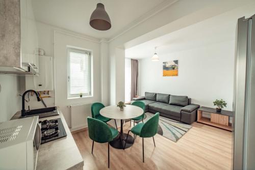 a living room with a couch and a table and chairs at Palace of Culture Dream Apartments and Studios Iasi in Iaşi