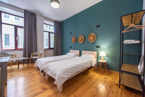 1 dormitorio con 2 camas y pared azul en Gallery Hostel Tbilisi, en Tiflis