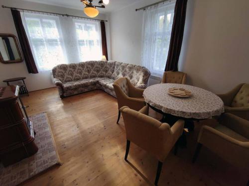 a living room with a couch and a table with chairs at CHALUPA NAD POTOKEM in Zlaté Hory