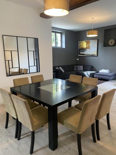 une salle à manger avec une table et des chaises noires dans l'établissement LES DOUVES, charmante dépendance du château, à Crèvecoeur-en Brie