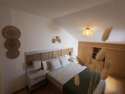 Dormitorio pequeño con cama y lámpara en Ático con terrazas en el caso antiguo, en Huesca