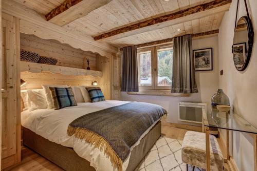 une chambre avec un grand lit et une fenêtre dans l'établissement Residence la Blaitiere, à Chamonix-Mont-Blanc