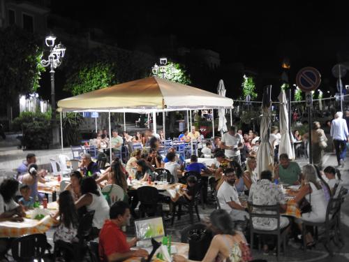 un gruppo di persone seduti ai tavoli al ristorante di notte di Leonardo a Capaci