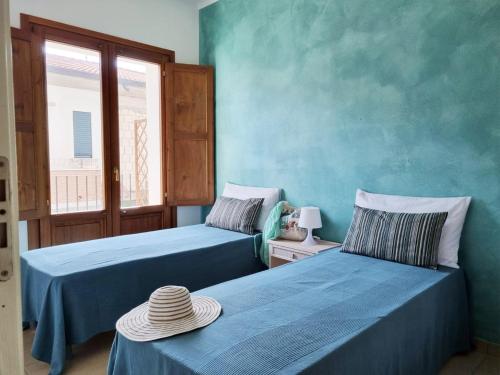 2 camas en una habitación con paredes azules en Barko Apartments & Suites, en Steccato
