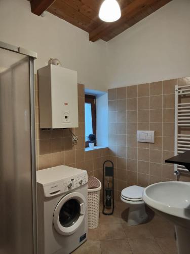 a bathroom with a washing machine and a sink at CASALE ANTICO SOBBORGO in Vitorchiano