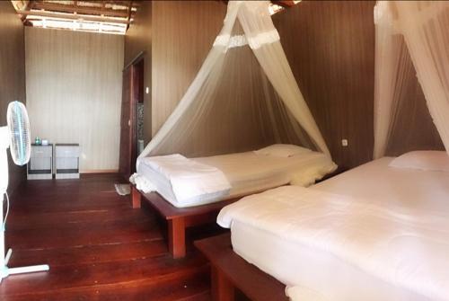sypialnia z 2 łóżkami i moskitierą w obiekcie Aldejus Homestay w mieście Yennanas Besir