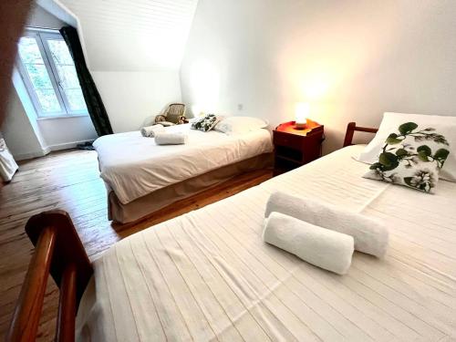 a bedroom with two beds and a window at TY AR STIVELL, l’équilibre entre terre et mer 4-7 personnes à MOELAN SUR MER in Moëlan-sur-Mer