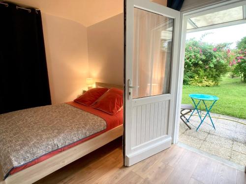 a bedroom with a bed and a sliding glass door at TY AR STIVELL, l’équilibre entre terre et mer 4-7 personnes à MOELAN SUR MER in Moëlan-sur-Mer