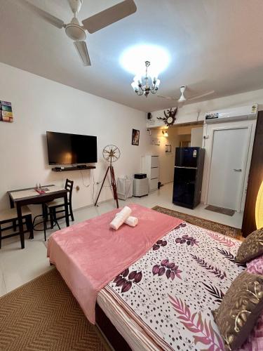 a bedroom with a large bed and a table at Good Stay Pool view Premium Studio Apartment 206 in Dabolim