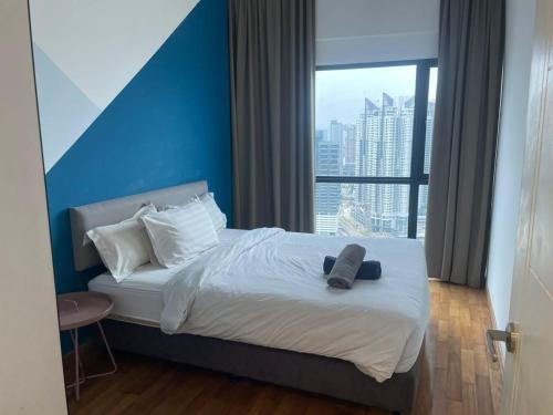 クアラルンプールにあるWelcome Home @Reizz Residenceの青い壁のベッドが備わるホテルルームです。