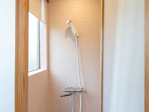 a shower in a bathroom with a window at Kur Park Nagayu in Nitta