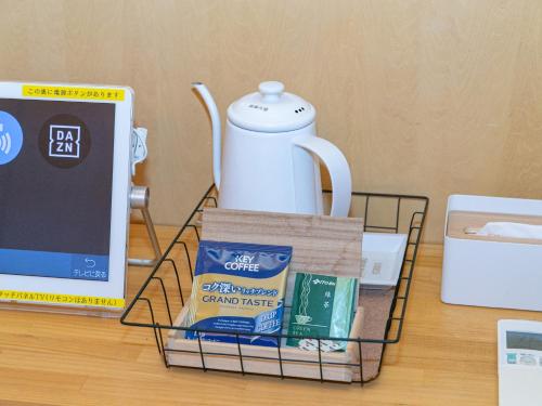 a table with a tea pot and a rack with food at Kur Park Nagayu in Nitta