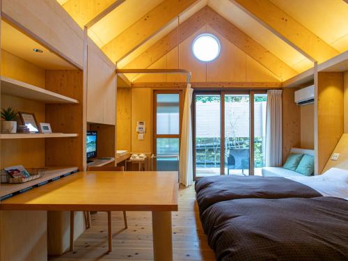 a bedroom with two beds and a table in a room at Kur Park Nagayu in Nitta