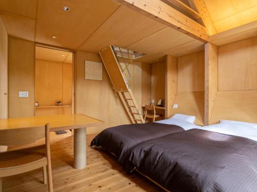 a bedroom with a bed and a desk and a ladder at Kur Park Nagayu in Nitta