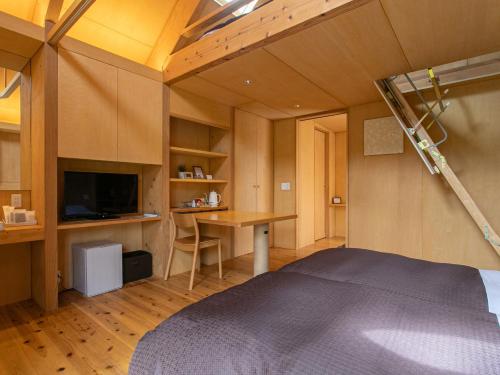 a bedroom with a bed and a desk and a tv at Kur Park Nagayu in Nitta