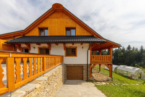 a large wooden house with a large deck at Wellness Chalupa Benešky in Vsetín