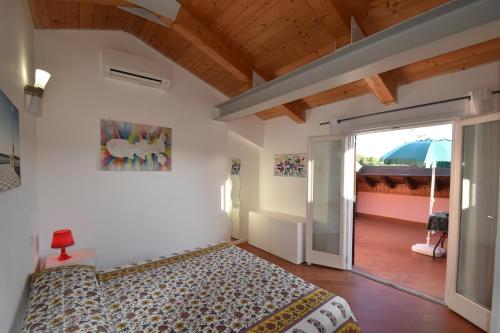 a bedroom with a bed and an open door at Complesso La Foce - Clima, parcheggi, spazi esterni privati in Marina di Campo